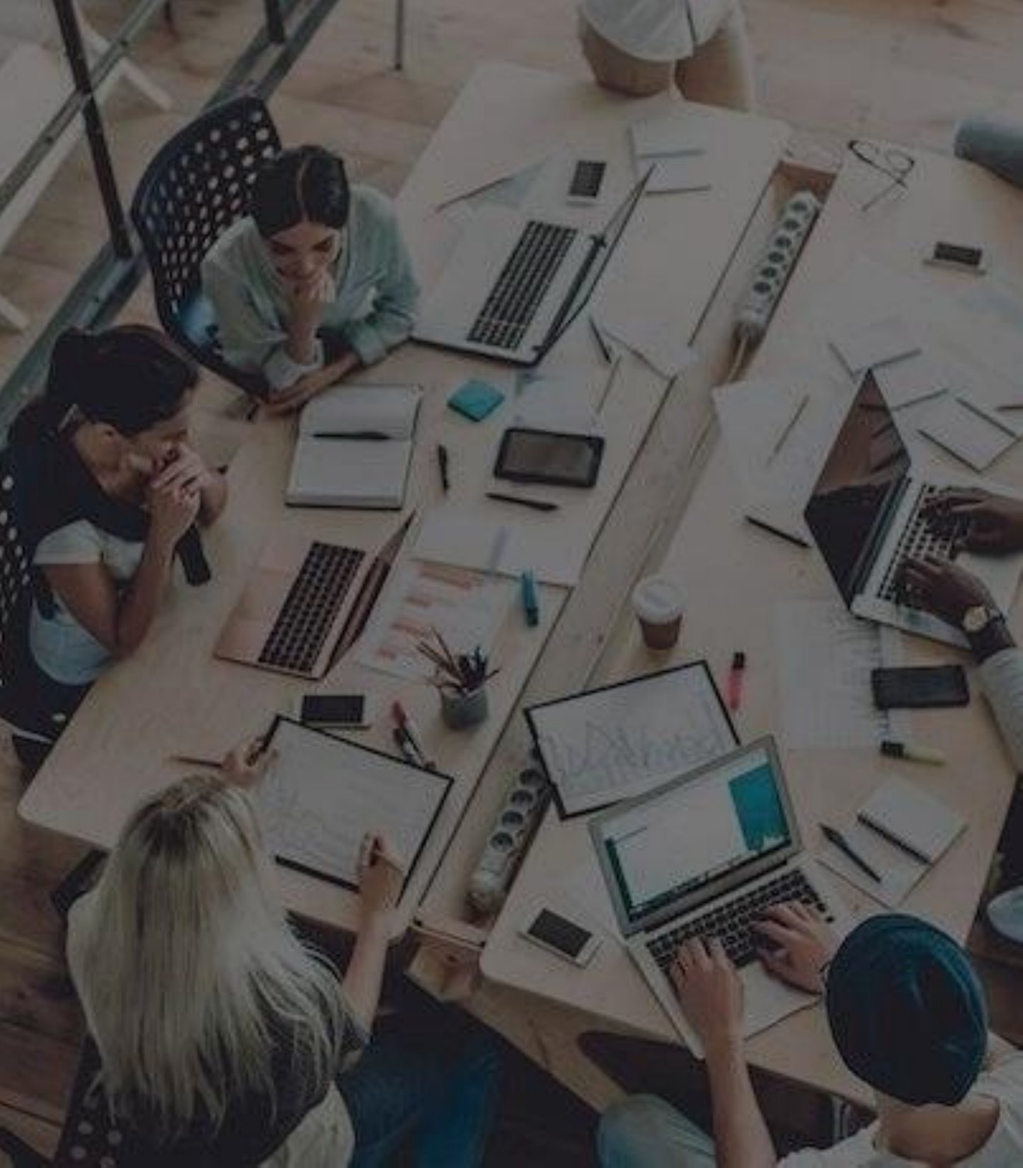 Equipe reunida em mesa de trabalho planejando um projeto