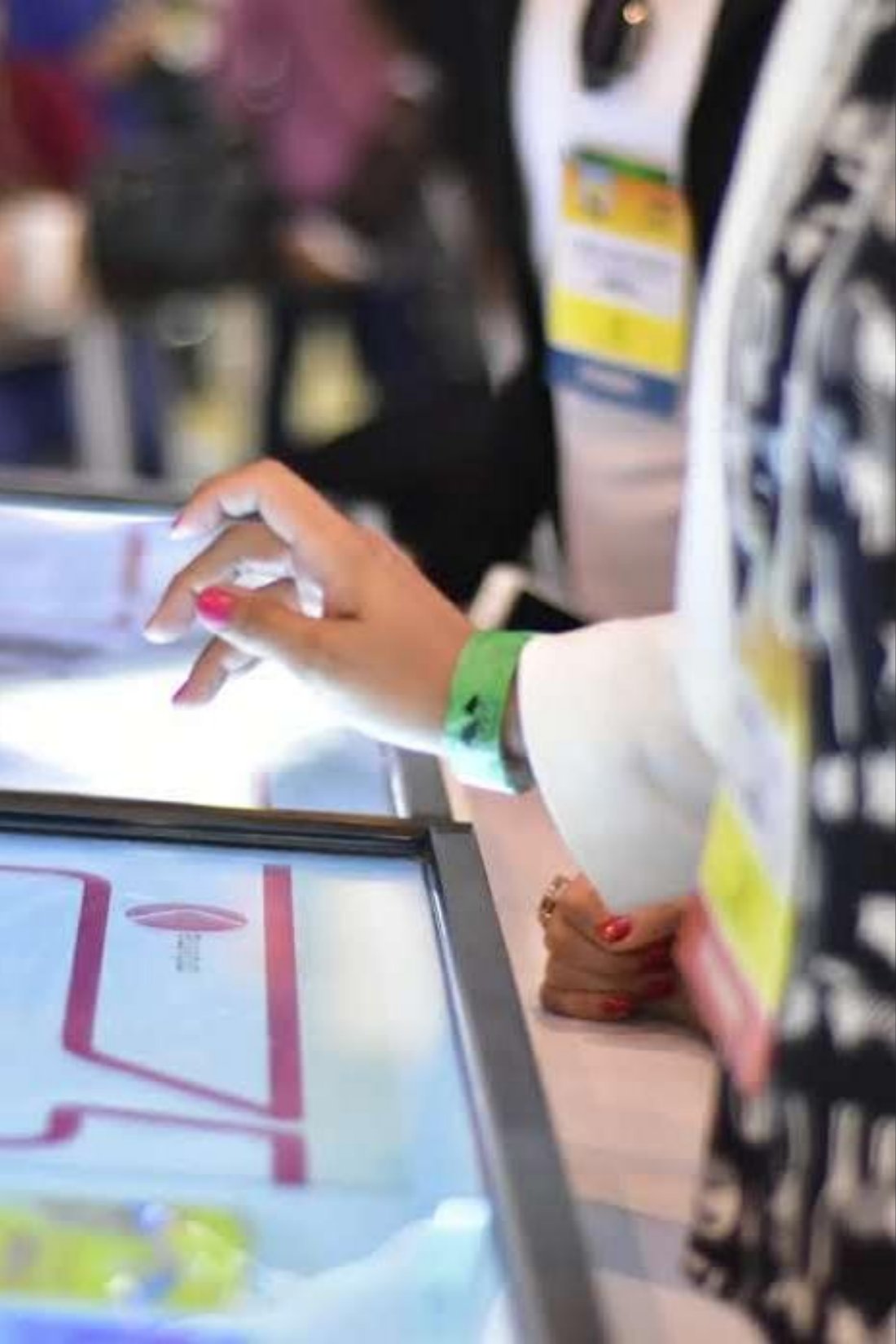 Participante interagindo com mesa touch em evento